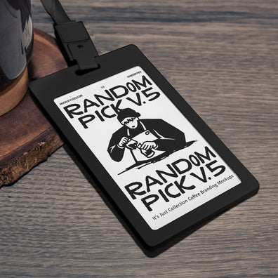 Black plastic ID card badge with green lanyard lying at an angle on a rustic wooden table next to a coffee mug and wood coaster, perfect for cafe staff badge branding mockup