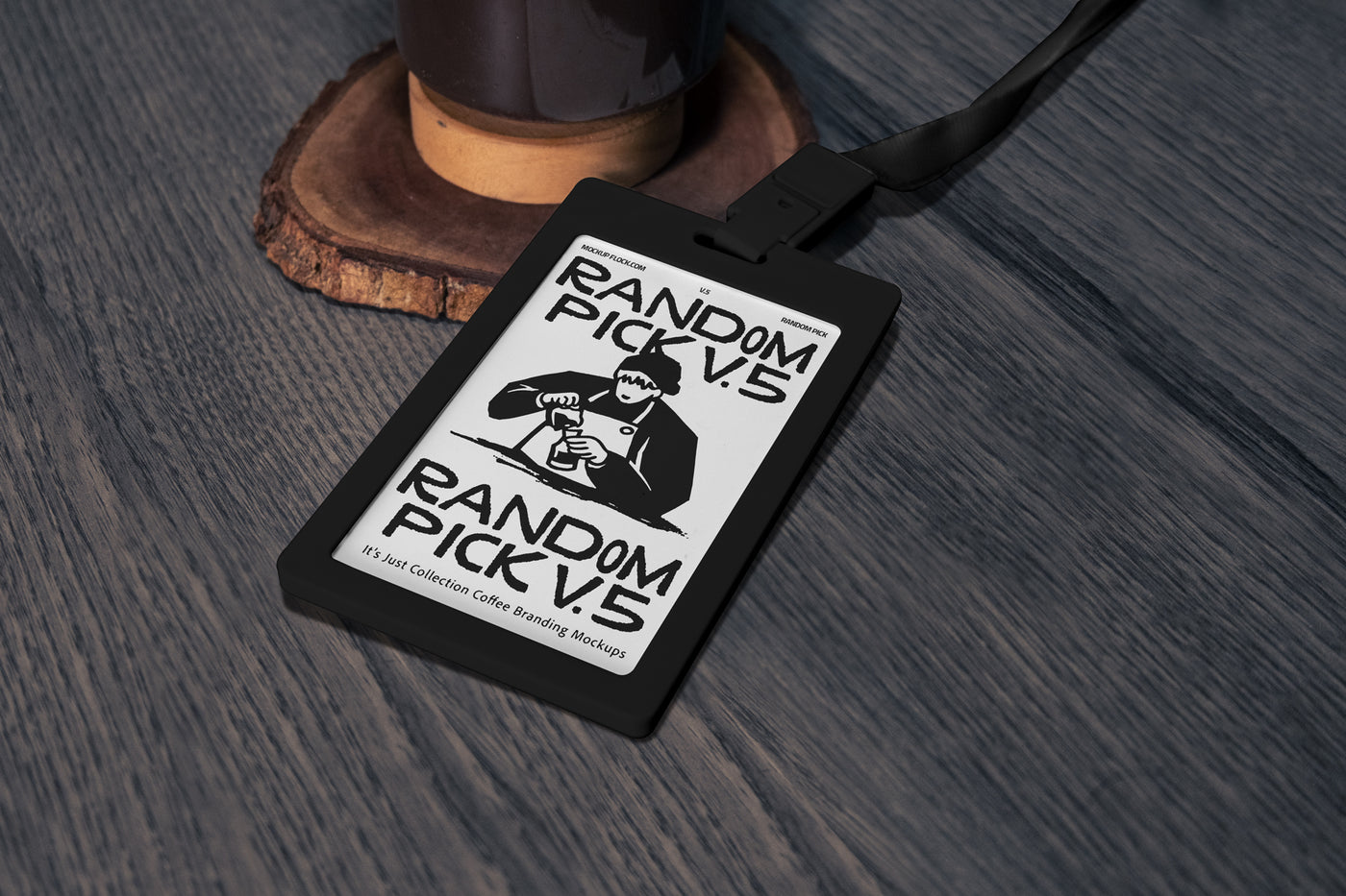 Black ID badge card with dark green lanyard lying flat on a textured wooden surface next to a coffee grinder base, top angle flat lay mockup for cafe branding