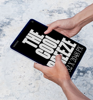 A person is holding an ipad labeled "THE COOL BREEZE 2732X2048 PX" in bold white text. Design by Mockup Flock