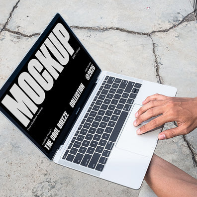 A person is holding an Macbook Device that says "MOCKUP THE COOL BREEZE COLLECTION @2025" in bold white text. Design by Mockup Flock