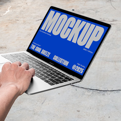 A person is holding an Macbook Device that says "MOCKUP THE COOL BREEZE COLLECTION @2025" in bold white text. Design by Mockup Flock