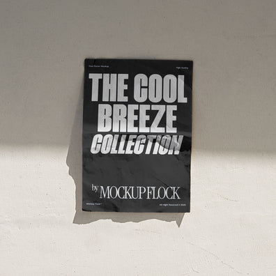 A vertical black poster mockup stick on the wall, with a crumpled paper texture, on a shaded background, on a shaded background. Design by Mockup Flock