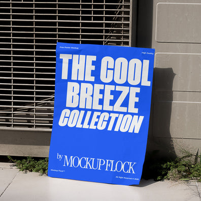 A blue Poster with white text reading THE COOL BREEZE COLLECTION BY MOCKUP FLOCK is lying on the grassy floor, attached to the outdoor air conditioner.
