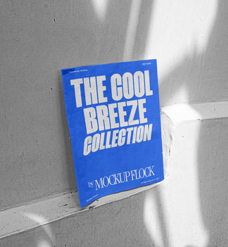 A blue poster with white text reading THE COOL BREEZE COLLECTION BY MOCKUP FLOCK, against the wall.