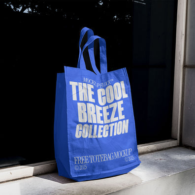 A blue tote bag with white text reading THE COOL BREEZE COLLECTION BY MOCKUP FLOCK, is stuck to the window.