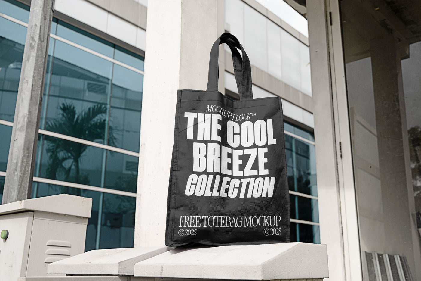 A black tote bag with white text reading THE COOL BREEZE COLLECTION BY MOCKUP FLOCK