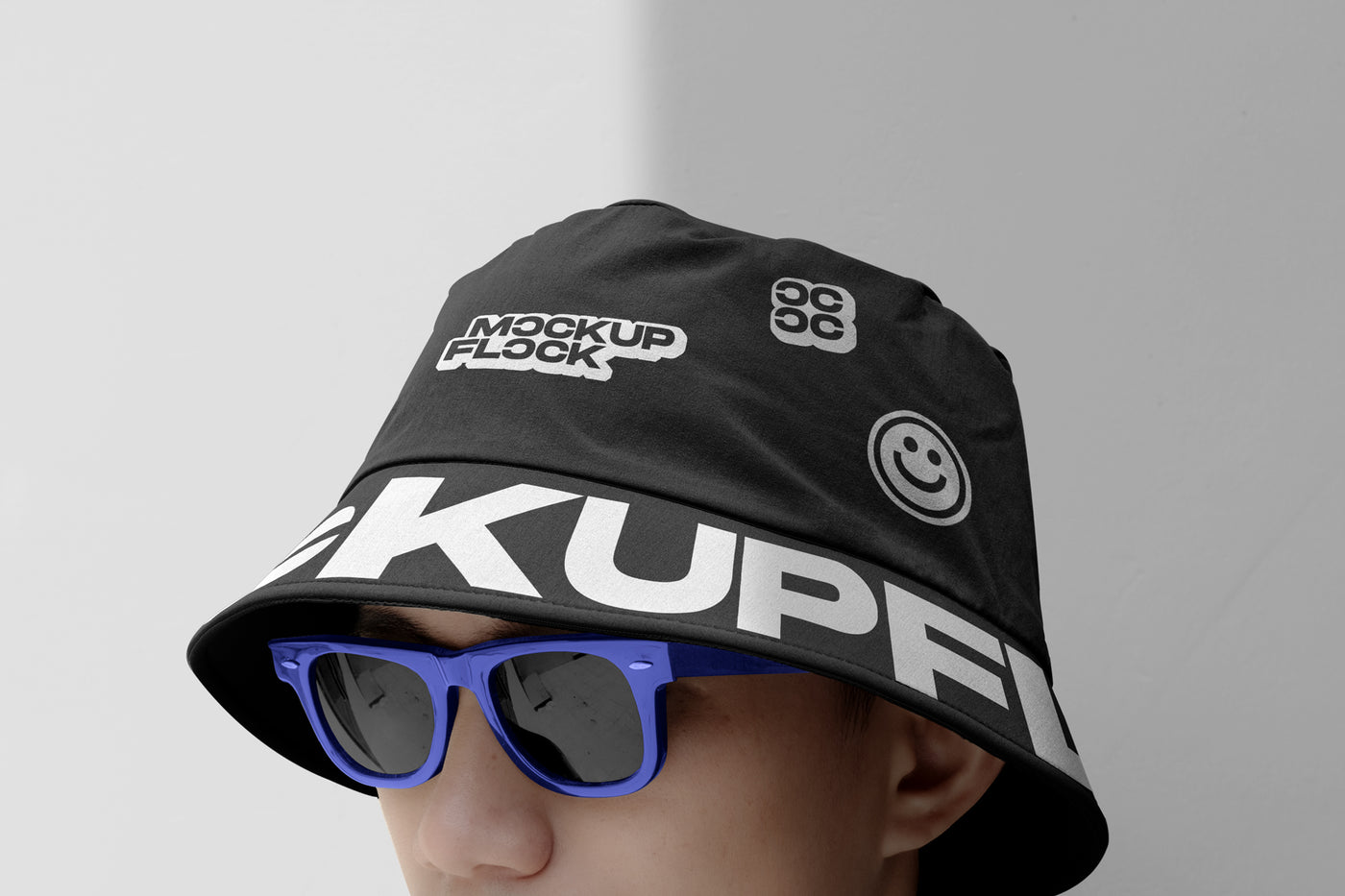 A person wearing a bucket hat and blue glasses, written MOCKUP FLOCK