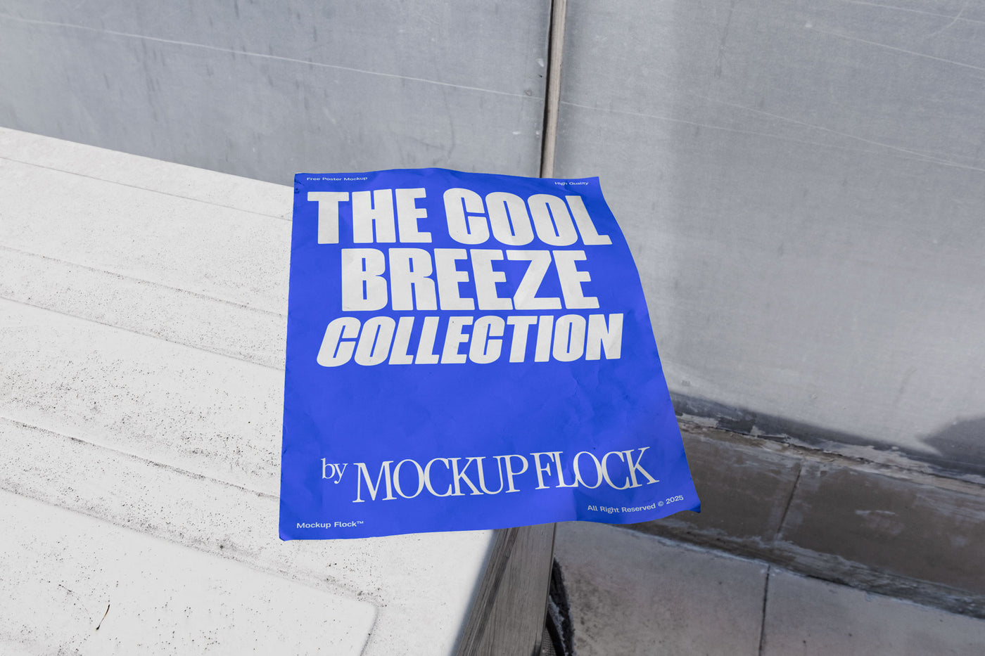 A blue Poster with white text reading THE COOL BREEZE COLLECTION BY MOCKUP FLOCK is lying on a box white, displayed in a outdoor setting.