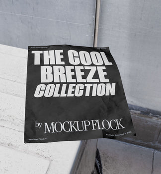 A black Poster with white text reading THE COOL BREEZE COLLECTION BY MOCKUP FLOCK is lying on a box white, displayed in a outdoor setting.