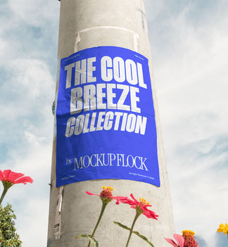 Vertical poster mounted on a pole with natural lighting, surrounded by red and yellow flowers against a blue sky.