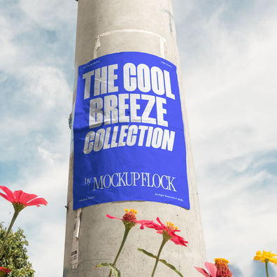 Vertical poster mounted on a pole with natural lighting, surrounded by red and yellow flowers against a blue sky.