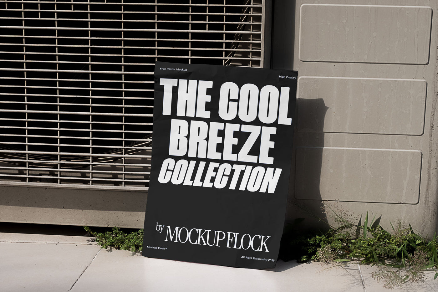 A black Poster with white text reading THE COOL BREEZE COLLECTION BY MOCKUP FLOCK is lying on the grassy floor, attached to the outdoor air conditioner.