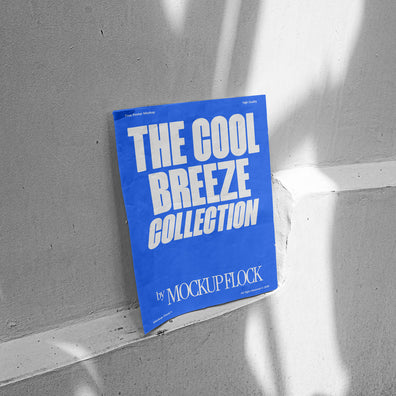 A blue poster with white text reading THE COOL BREEZE COLLECTION BY MOCKUP FLOCK, against the wall.