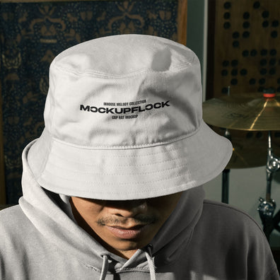 High quality bucket hat mockup of someone wearing a bucket and hoodie in a music studio. Aesthetic print mockup created for Adobe Photoshop