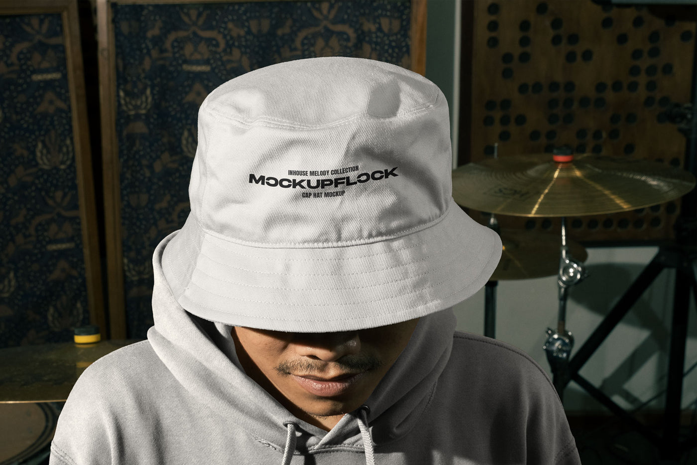 High quality bucket hat mockup of someone wearing a bucket and hoodie in a music studio. Aesthetic print mockup created for Adobe Photoshop