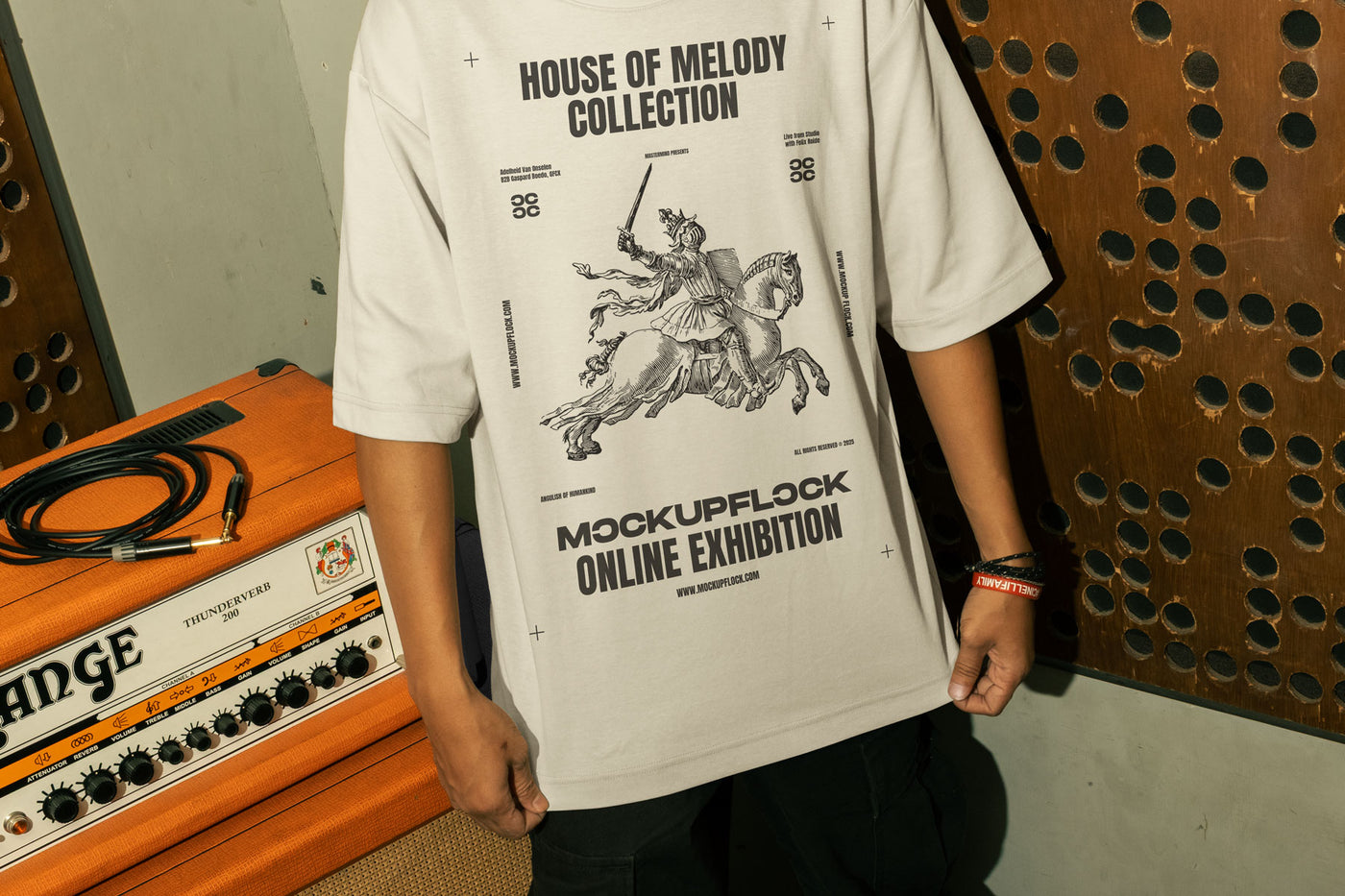 This high-quality t-shirt mockup features a person standing in front of an orange amplifier in a music studio. This aesthetic print mockup was created in Adobe Photoshop.