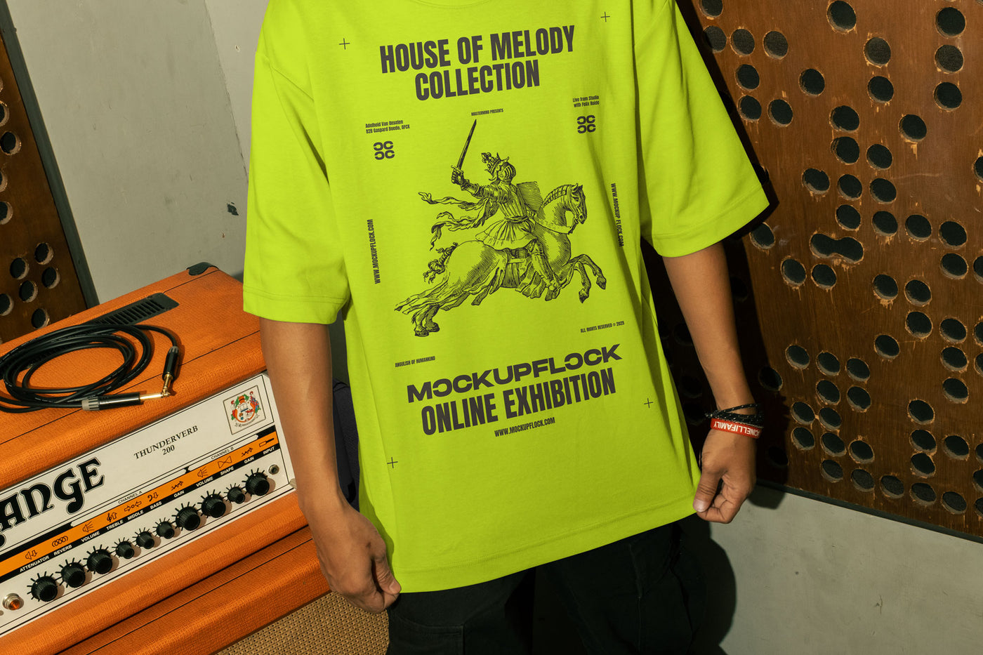 This high-quality t-shirt mockup features a person standing in front of an orange amplifier in a music studio. This aesthetic print mockup was created in Adobe Photoshop.