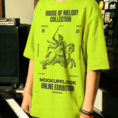 This high-quality t-shirt mockup features a person standing in front of an orange amplifier in a music studio. This aesthetic print mockup was created in Adobe Photoshop.