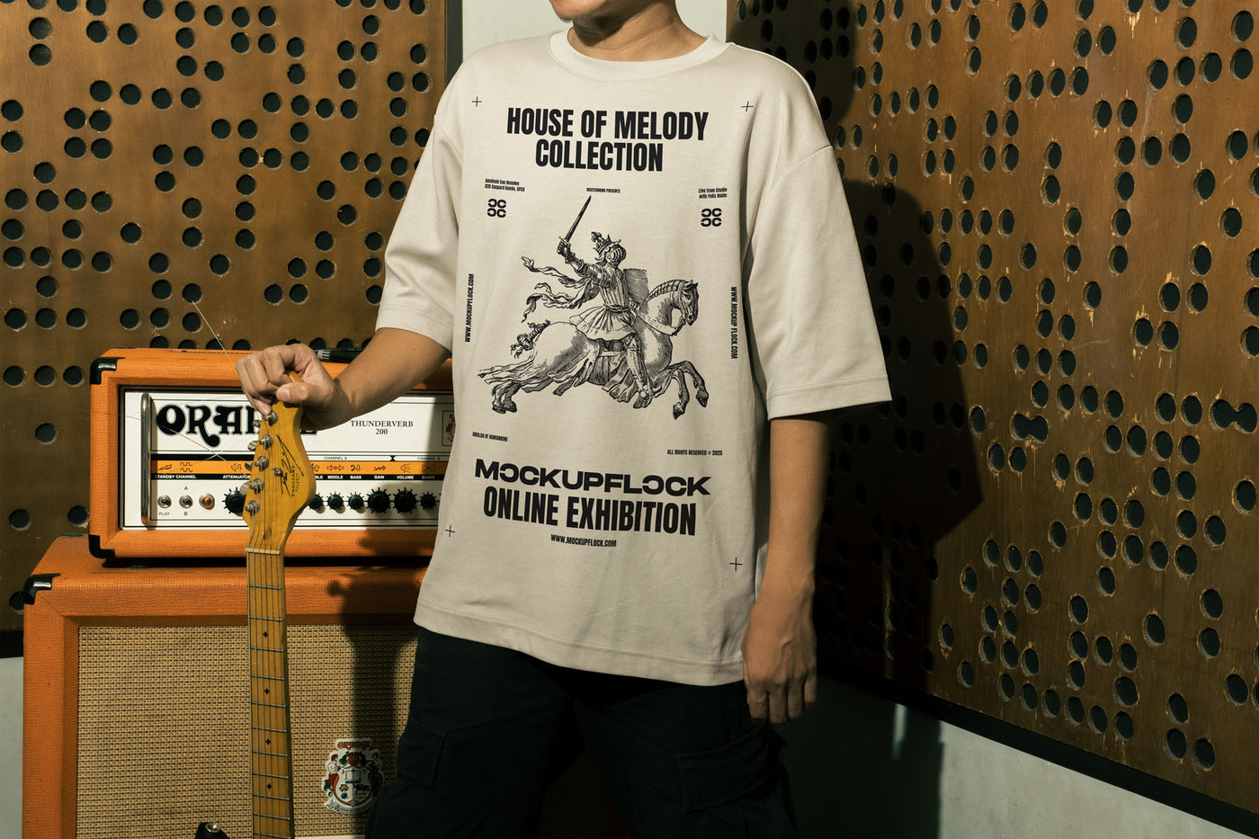 This high quality t-shirt mockup features a person standing in front of an amplifier in a music studio. This aesthetic print mockup was created in Adobe Photoshop.