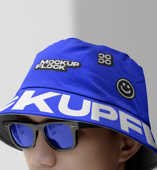 A person wearing a bucket hat and blue glasses, written MOCKUP FLOCK