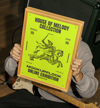 person holding a poster frame mockup in a music studio.