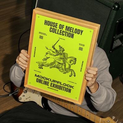 person holding a poster frame mockup in a music studio.