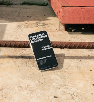 Mockup Flock Real Steel Collection Iphone mockup displayed on a concrete floor with industrial metal rods for realistic product presentation.