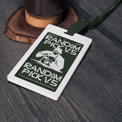 White ID badge card with dark green lanyard lying flat on a textured wooden surface next to a coffee grinder base, top angle flat lay mockup for cafe branding