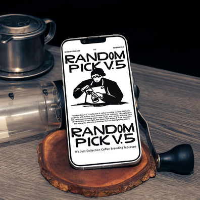 White iPhone standing upright on a wood slice coaster surrounded by coffee props including a manual grinder and Vietnamese drip filter on a wooden table with dark background