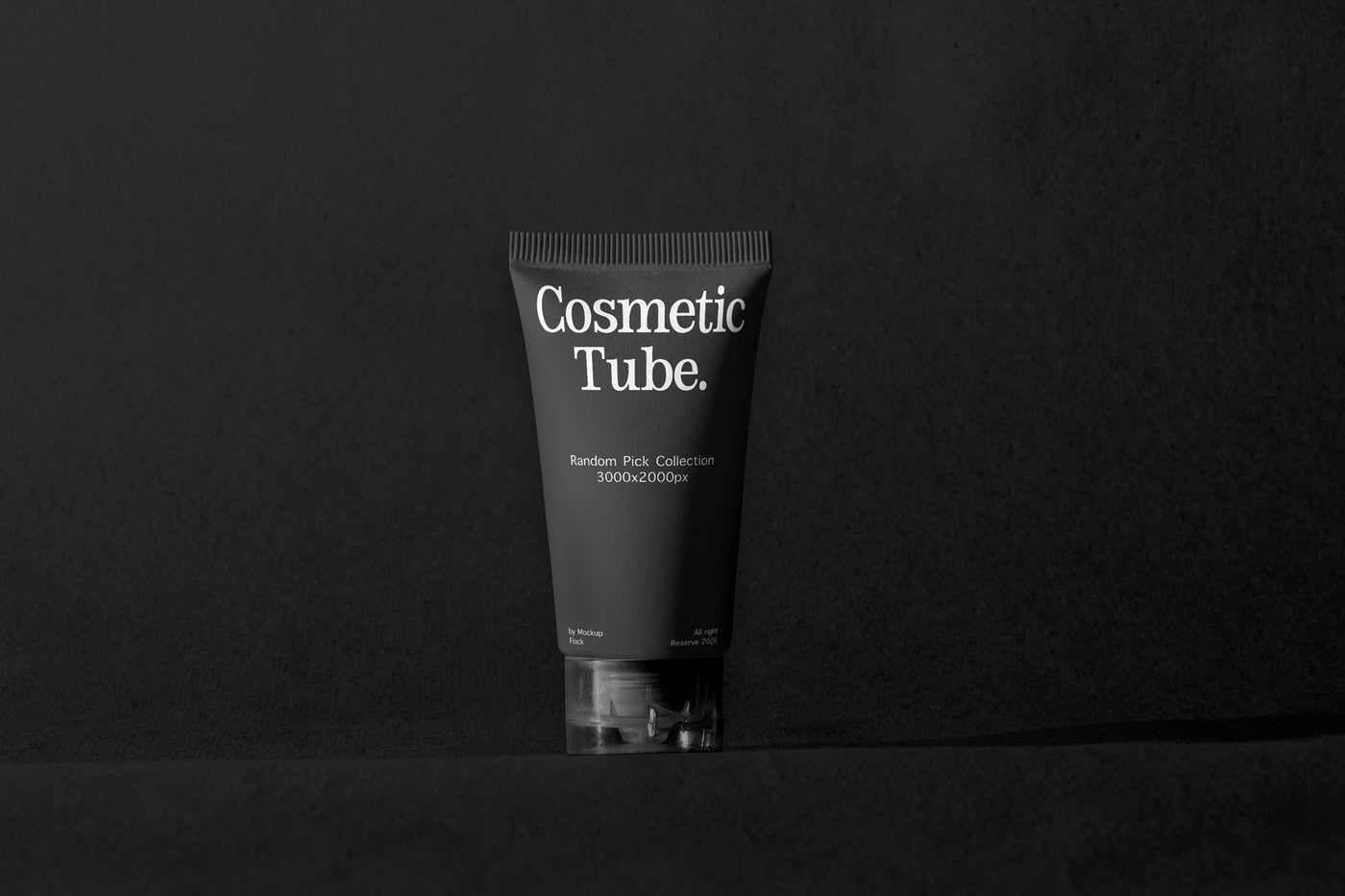 A matte black cosmetic tube with white text reading 'Cosmetic Tube.' and smaller text below, standing upright on a dark surface against a dark background.