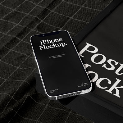 A smartphone mockup with a black screen displaying 'iPhone Mockup.' lies on a dark plaid fabric surface next to a black poster mockup cover with large white text.