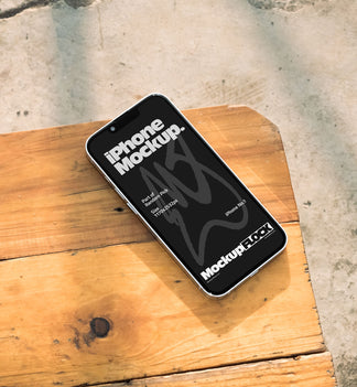 Realistic black iPhone mockup resting on a bright outdoor wooden bench with soft natural lighting and shadows