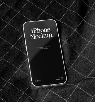 A smartphone mockup with a black screen displaying the text 'iPhone Mockup.' in white, resting on a black plaid fabric background.