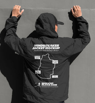 Black hooded windbreaker jacket mockup back view with model's hands raised against grey wall