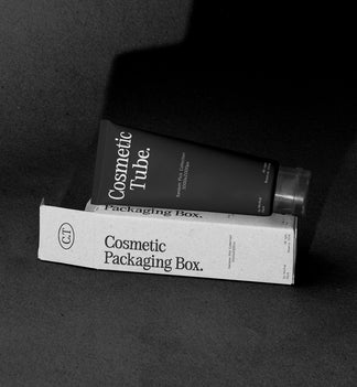 Black cosmetic tube leaning on White packaging box mockup, terracotta studio backdrop