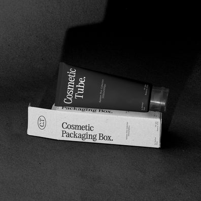 Black cosmetic tube leaning on White packaging box mockup, terracotta studio backdrop