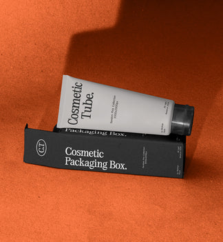 White cosmetic tube leaning on black packaging box mockup, terracotta studio backdrop