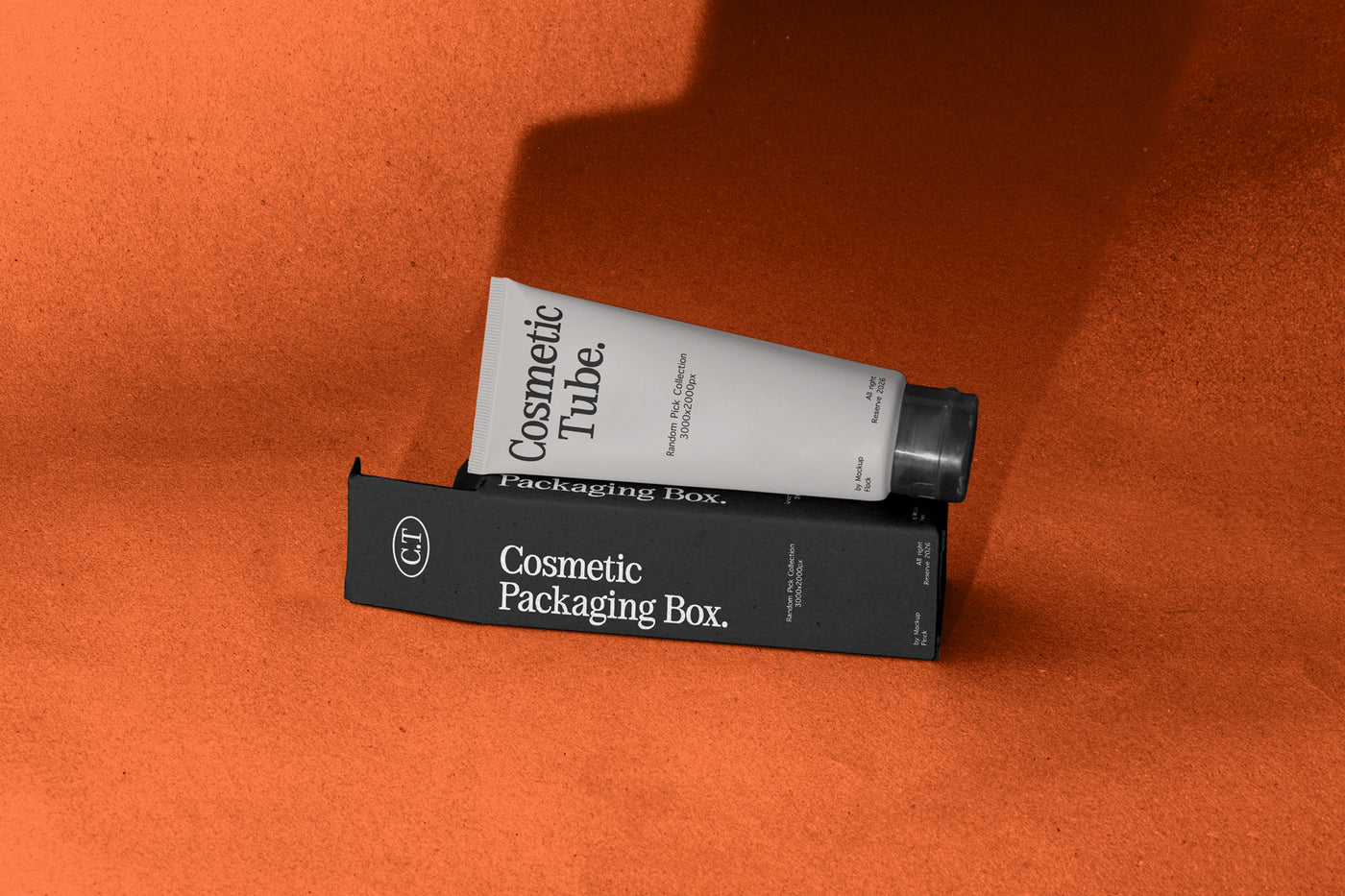 White cosmetic tube leaning on black packaging box mockup, terracotta studio backdrop