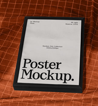 A framed poster mockup with a black frame and a white insert displaying the text 'Poster Mockup.' in bold black font, placed on an orange-brown textured fabric background with a grid pattern.