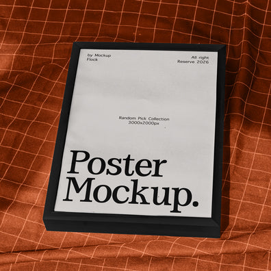 A framed poster mockup with a black frame and a white insert displaying the text 'Poster Mockup.' in bold black font, placed on an orange-brown textured fabric background with a grid pattern.