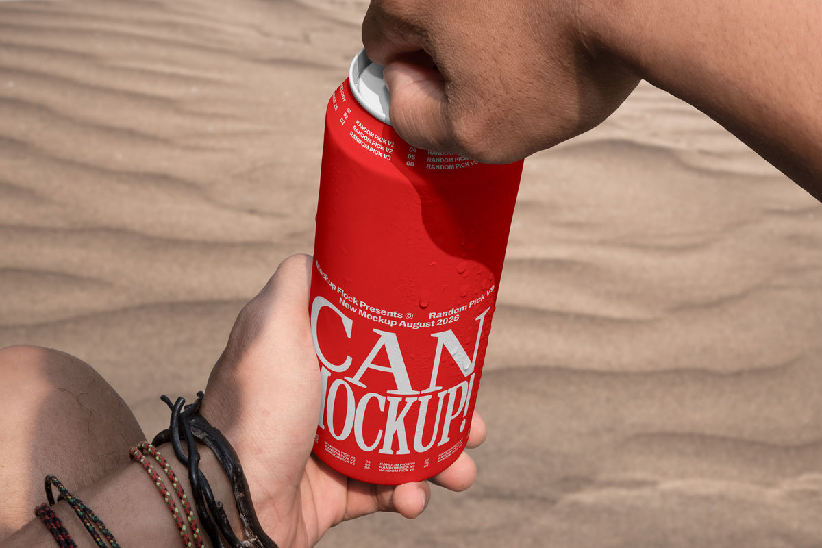 Close-up of hands opening a red beverage can mockup outdoors with desert sand background, lifestyle mockup