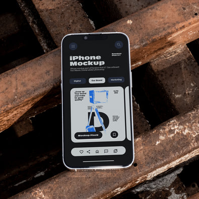iPhone lying flat face-up on rusty industrial metal grates outdoors in bright daylight, showing app UI mockup design, dark urban industrial style