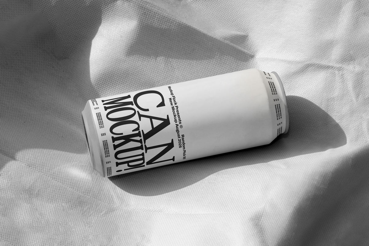 White beverage can lying on wrinkled white fabric with dramatic shadow, minimal studio mockup