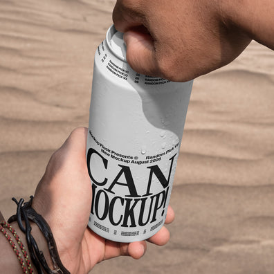 Close-up of hands opening a white beverage can mockup outdoors with desert sand background, lifestyle mockup