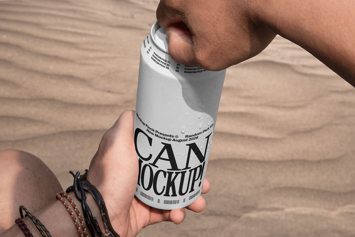 Close-up of hands opening a white beverage can mockup outdoors with desert sand background, lifestyle mockup