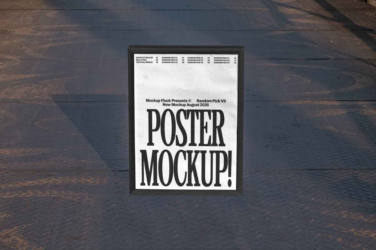 Black framed poster mockup standing upright on a dark textured metal floor with soft shadow overlay
